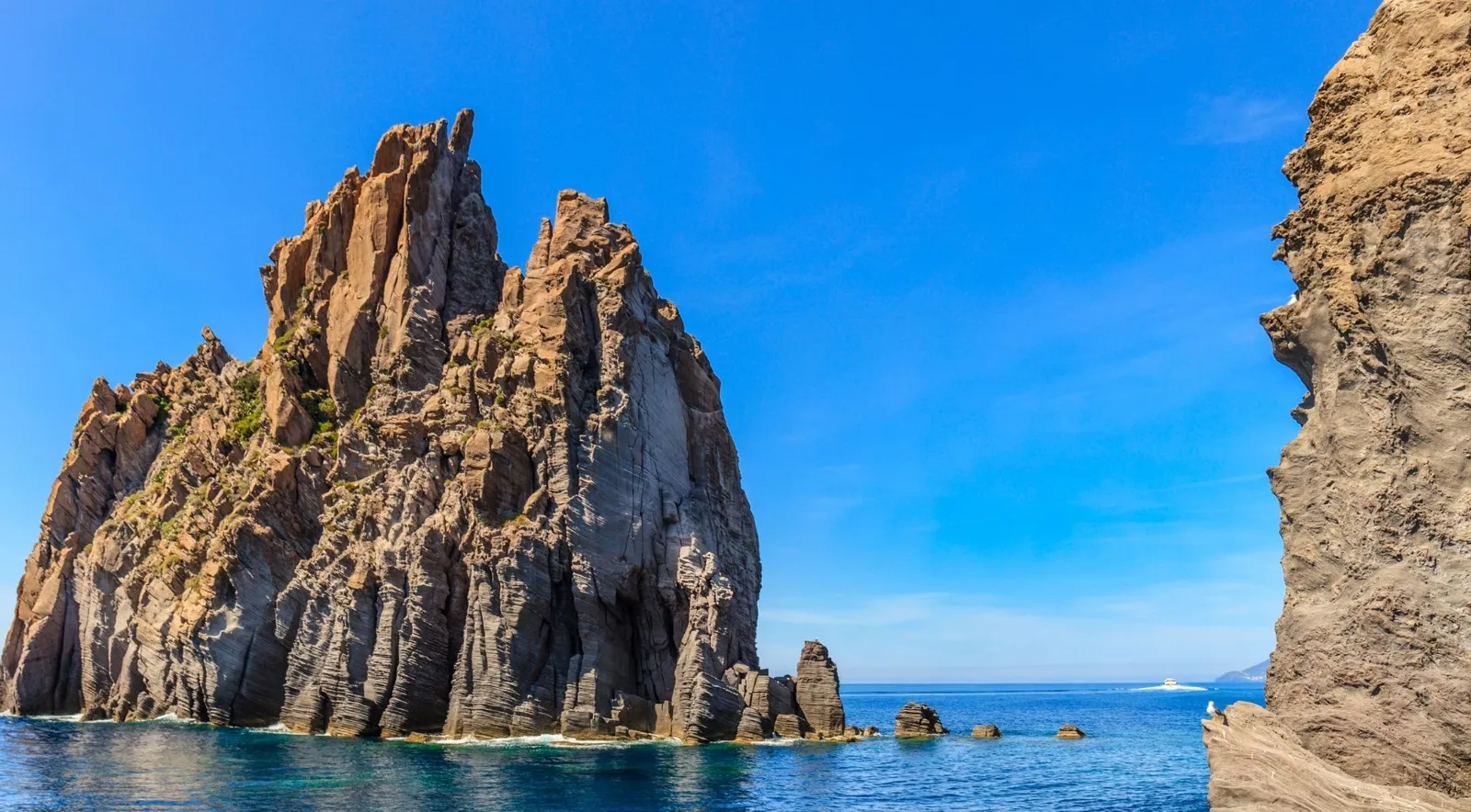 Jagged volcanic rock stacks rising from deep blue water