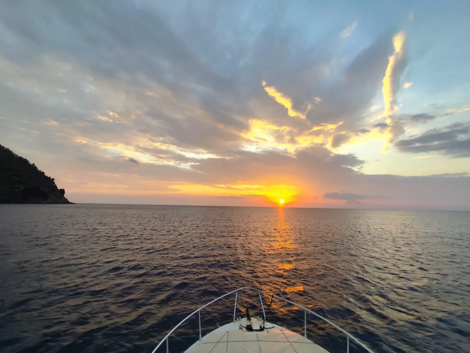 Sunset over the sea from the stern of a small boat