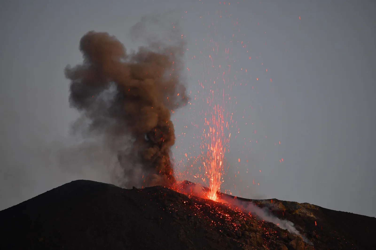 Ash and lava from the craters in grey evening light