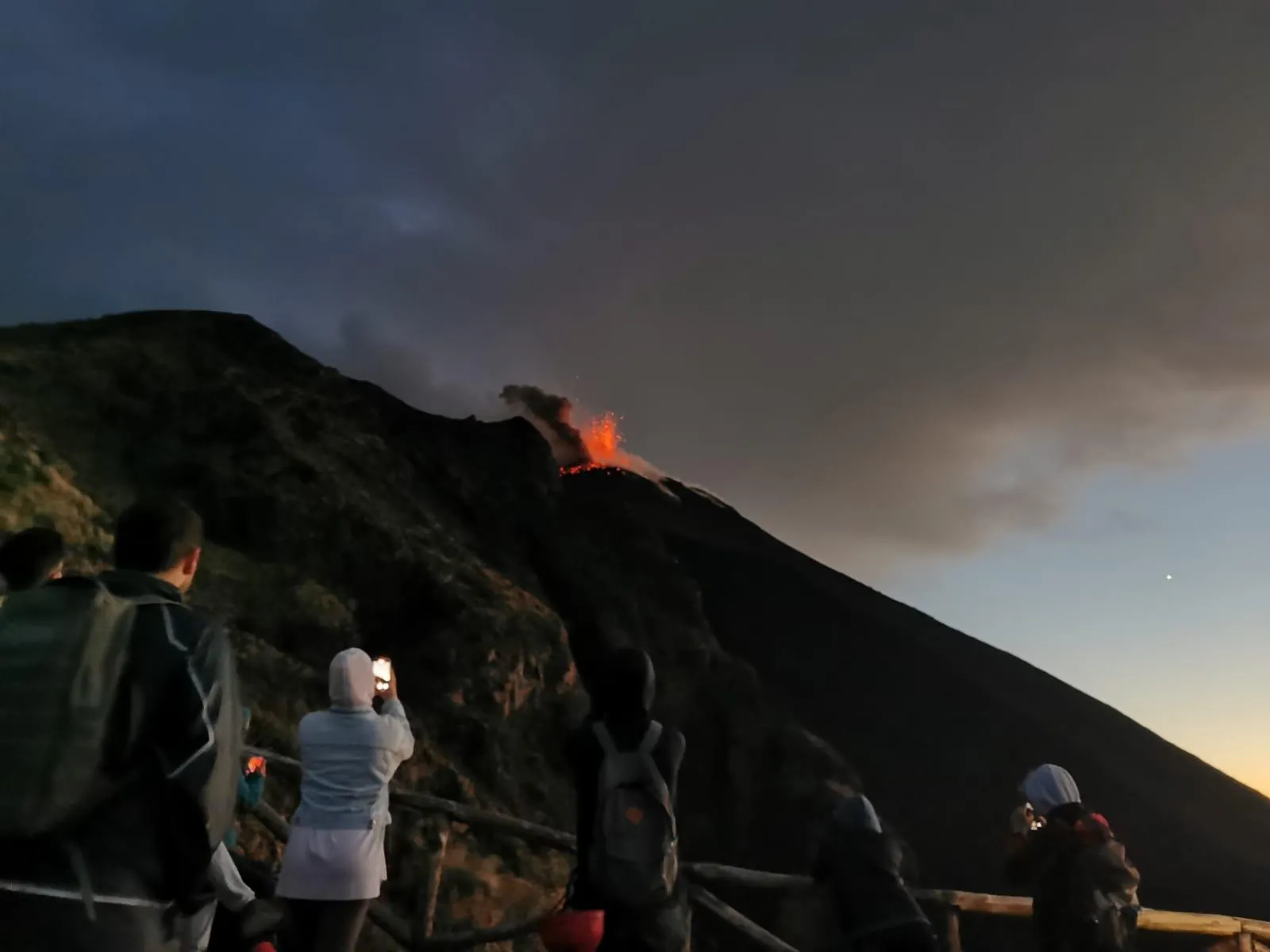 Hikers on the ridge with a glow at the summit