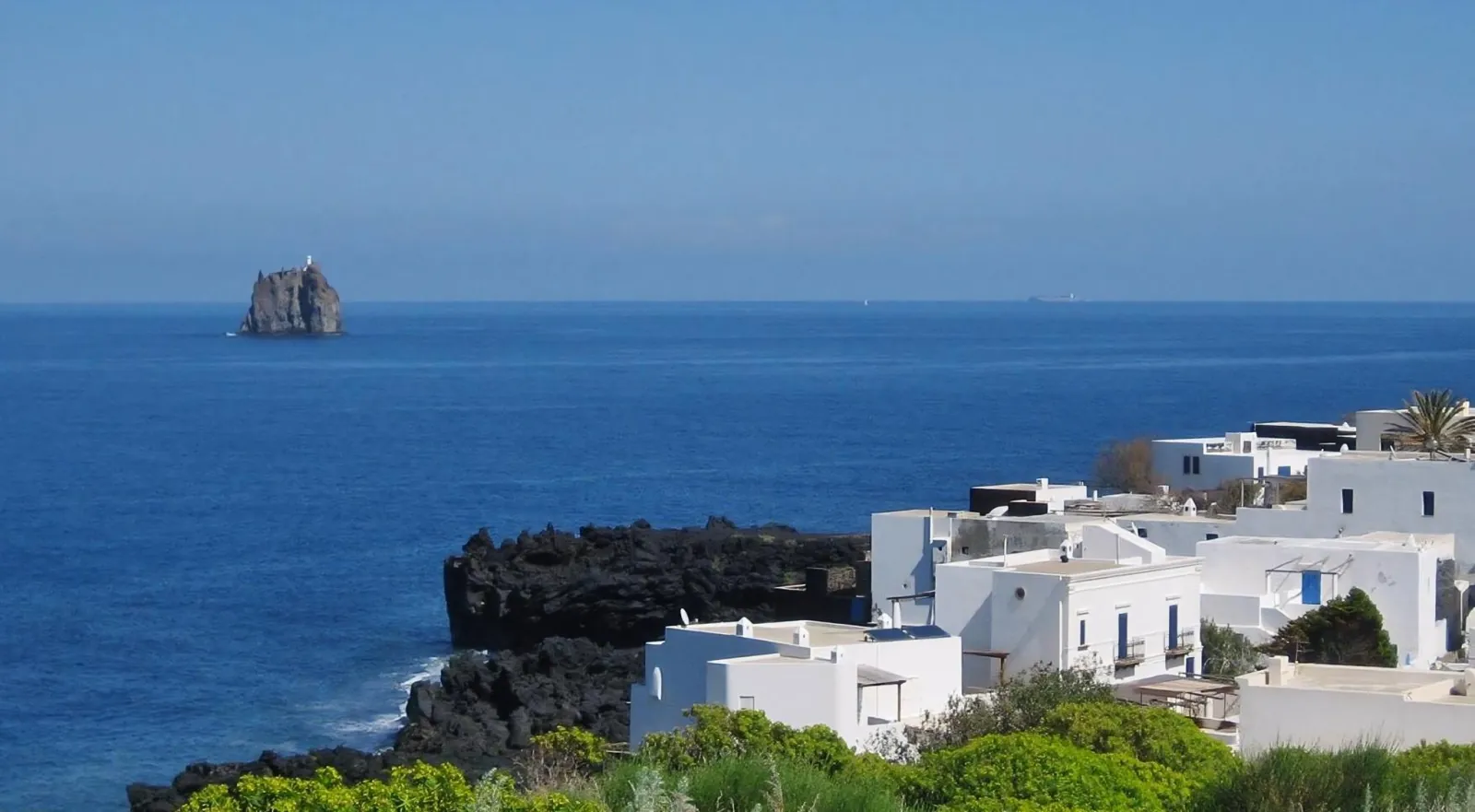 White houses on the cliff edge above a calm sea