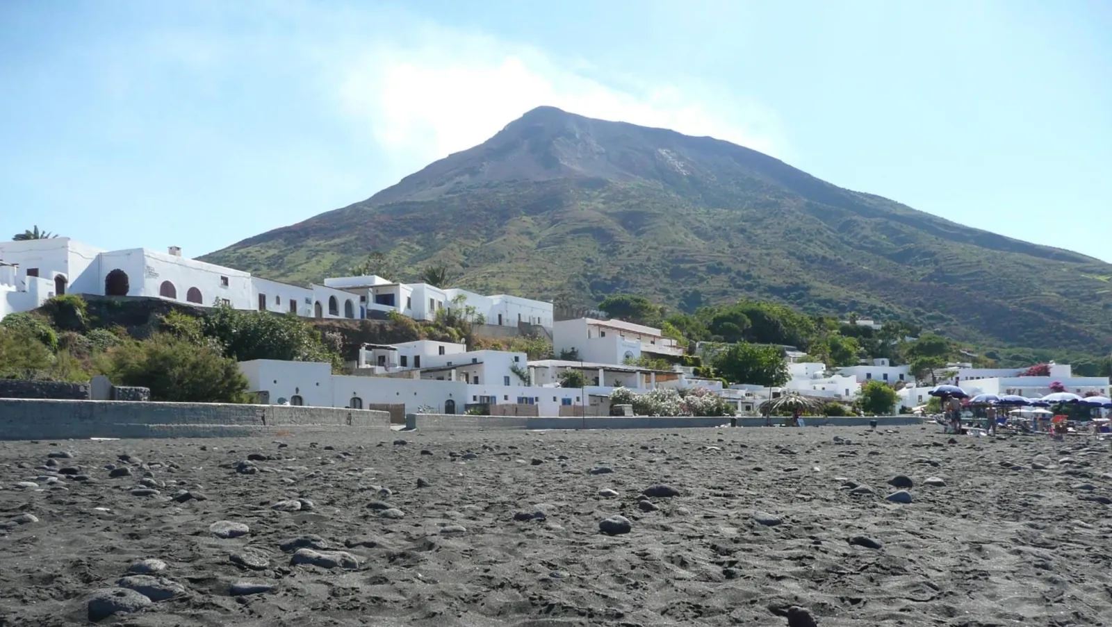 Stromboli rising above its village and black beach