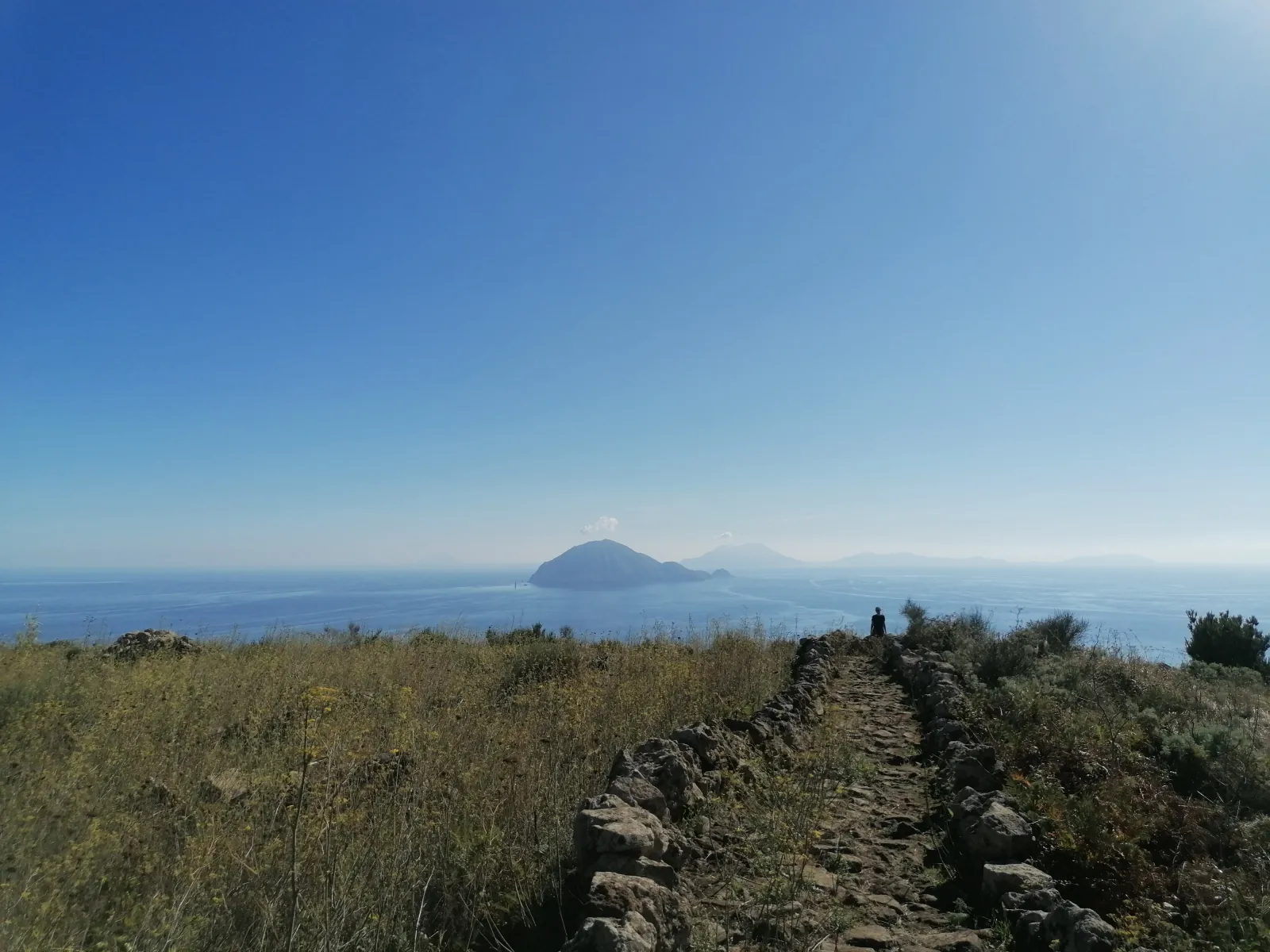 Stromboli on the horizon from a grassy headland