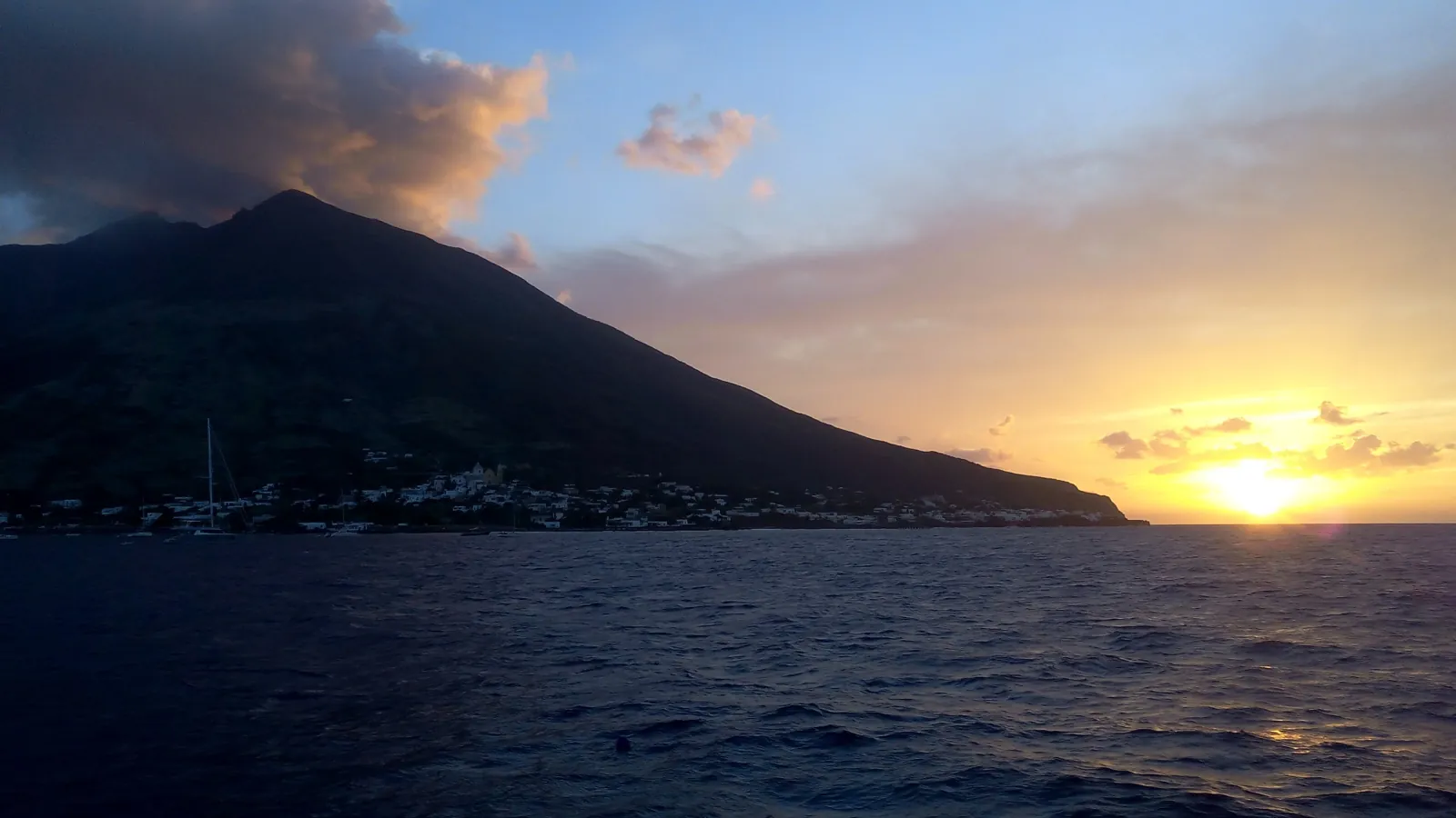Stromboli in silhouette against the sunset from the sea