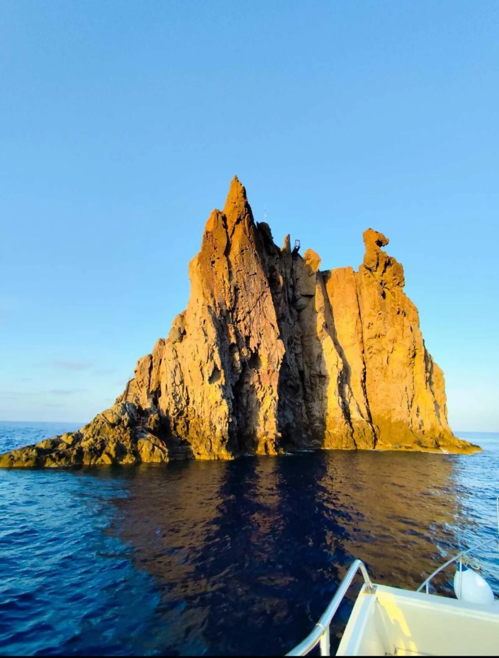 A golden rock spire lit by the evening sun