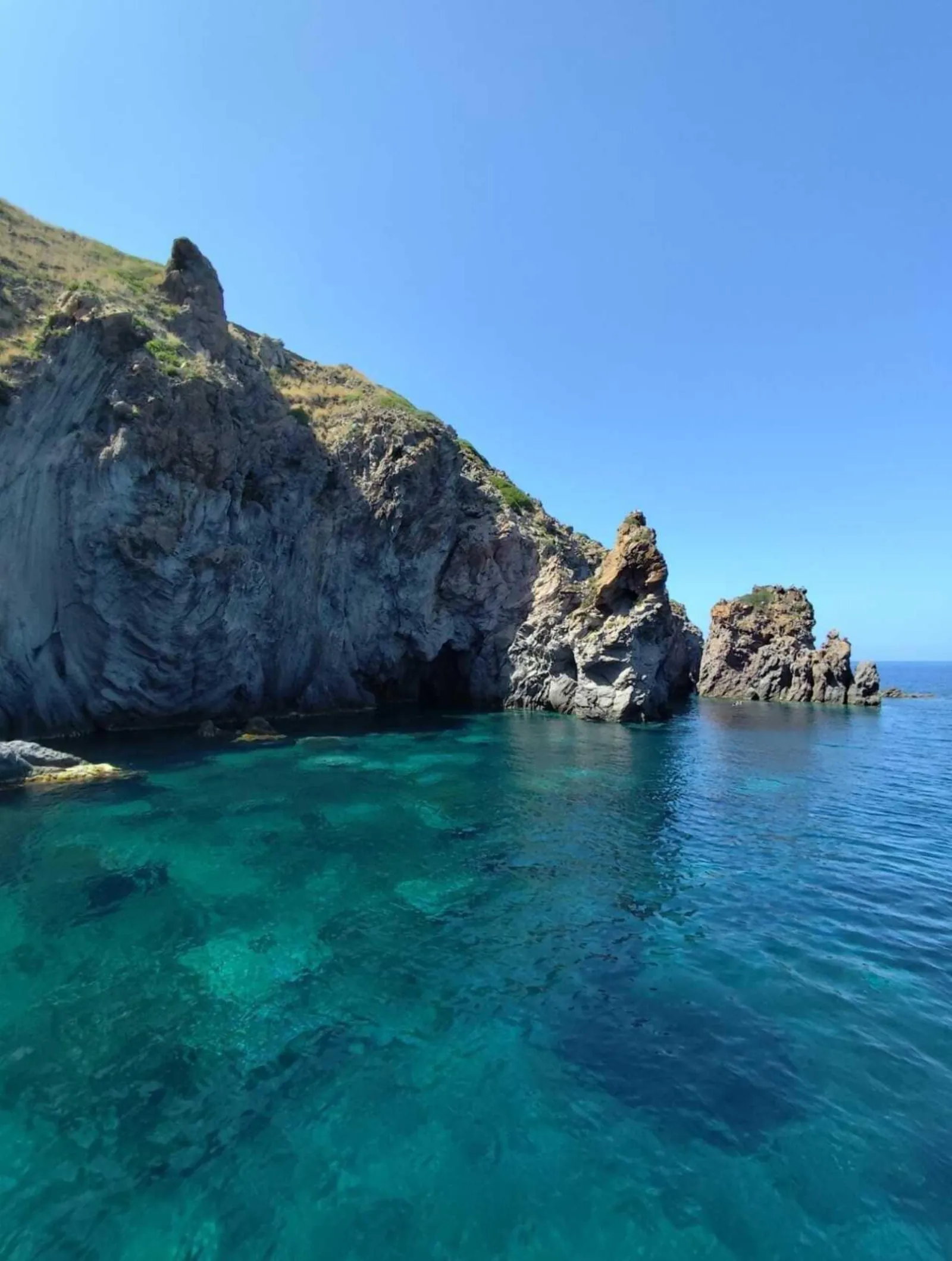 Rocky headland above clear green water