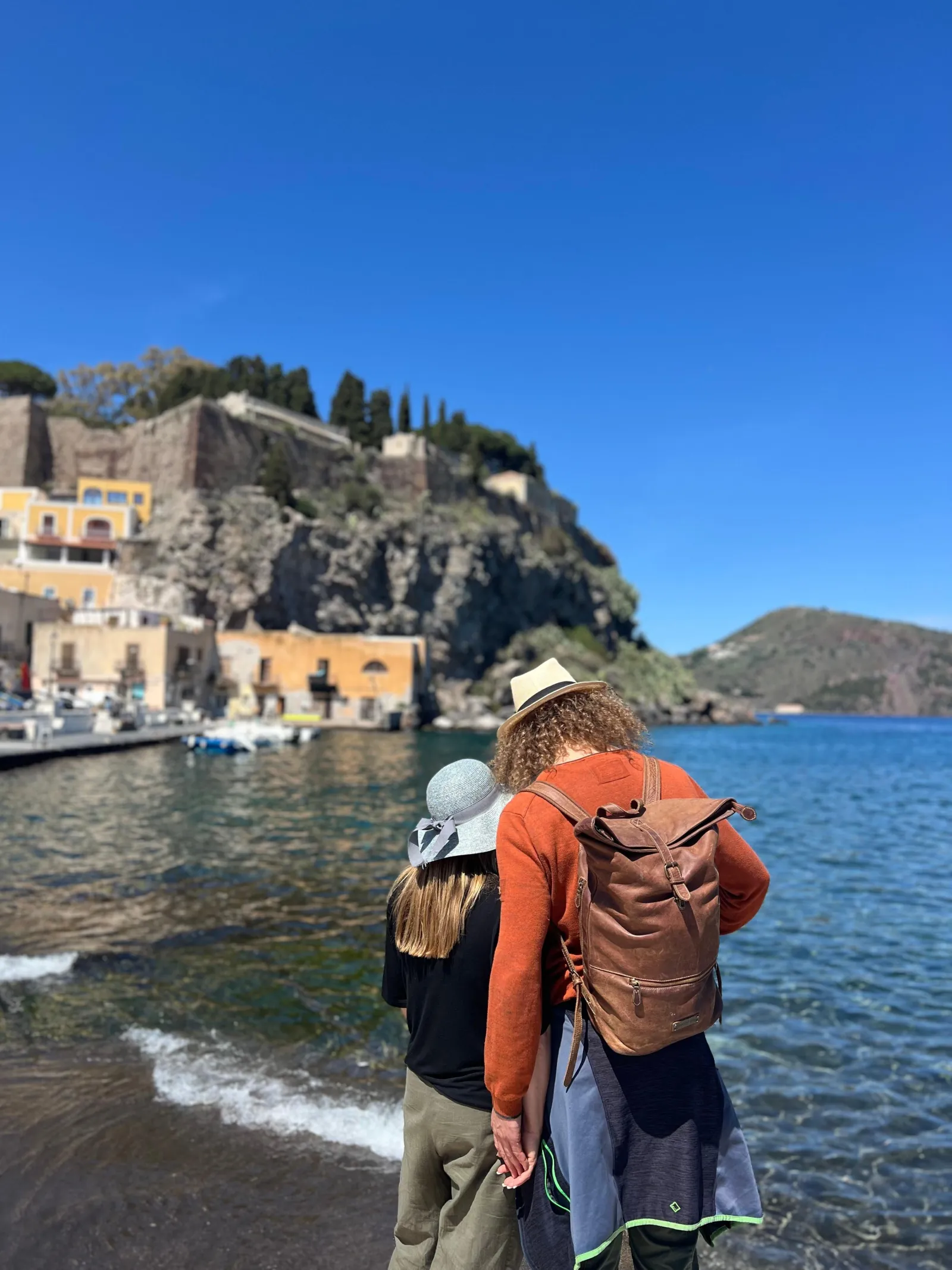 A visitor with a backpack on a dark island beach