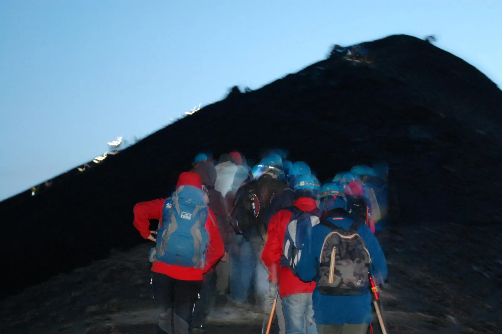 Hikers in helmets watching the craters